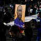 Demonstrators carry a scroll listing the names of people killed by police during a march in honor of George Floyd on March 7, 2021 in Minneapolis, Minnesota.